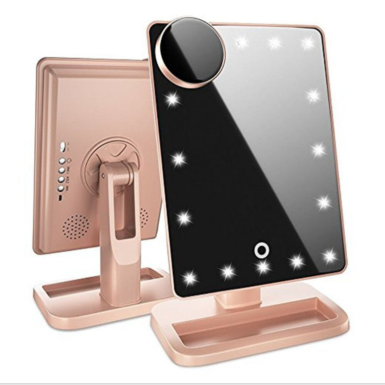 Touch screen makeup mirror with speaker featuring LED lights and a side magnifying mirror in stylish pink design.