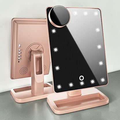 Touch screen makeup mirror with speaker featuring LED lights and a side magnifying mirror in stylish pink design.