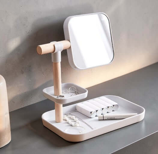 Cosmetics Storage Box with Mirror on a stylish counter with jewelry and beauty products organized.