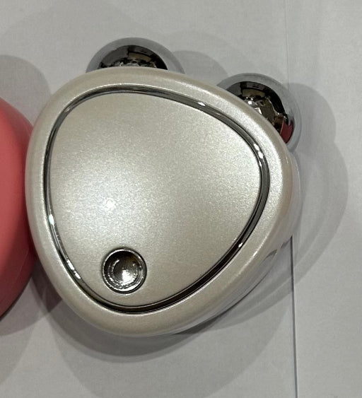 Microcurrent beauty massager in pink with charging cable and clear case for skincare enhancement.